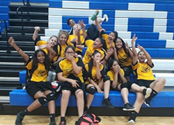 Volleyball team sitting and laughing on the school bleachers